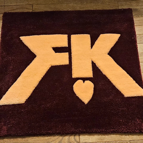“Tufted fiber art of the First/Khaotung ship logo with bold colors, plush texture, and sculpted carving, handmade for BL fans