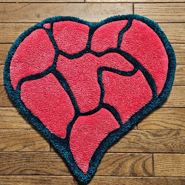 Shattered Heart hand-tufted functional fiber art in vibrant pink and teal with a cracked heart design