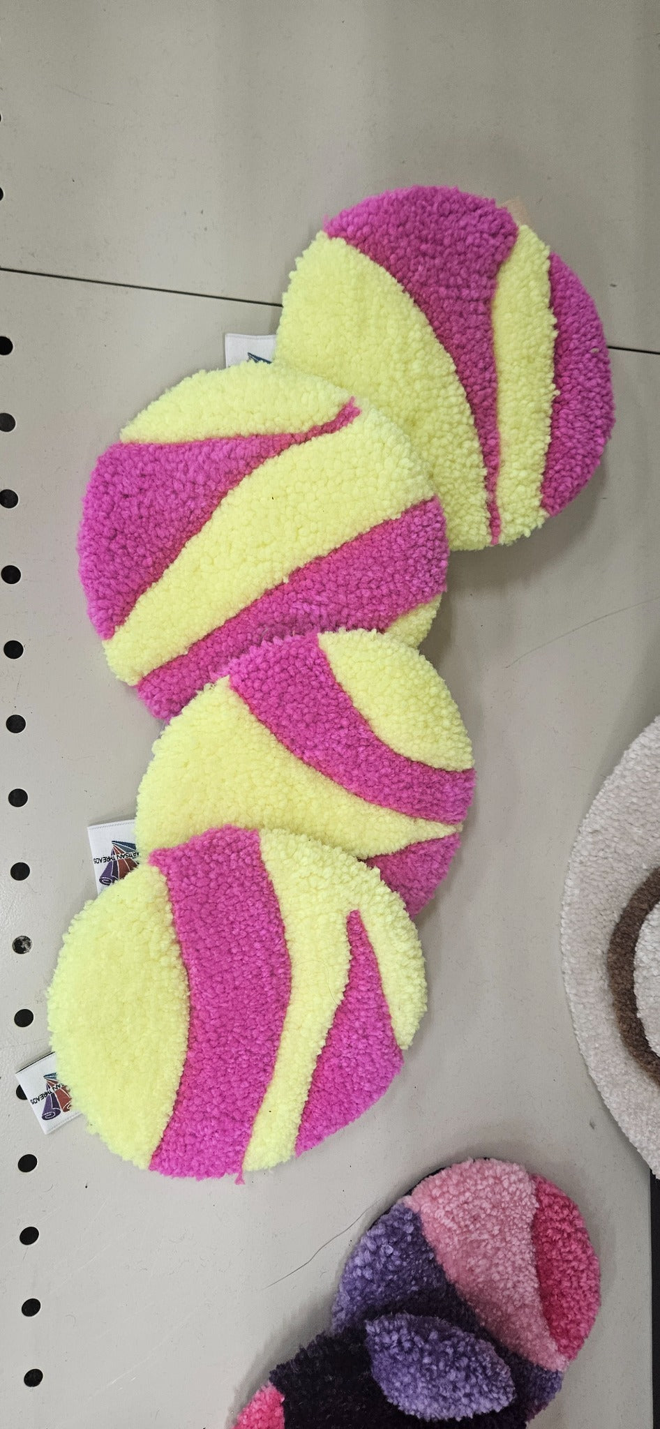 Hand-tufted fiber art coaster set in bright pink and pale yellow
