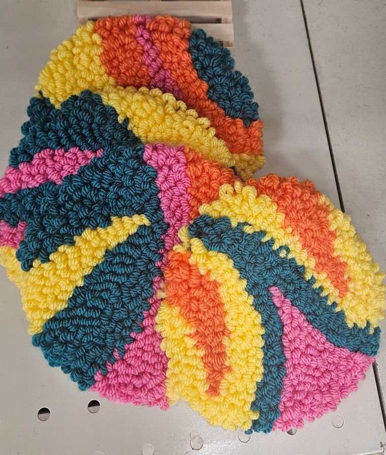 Hand-tufted fiber art coaster set in orange, yellow, teal, and pink