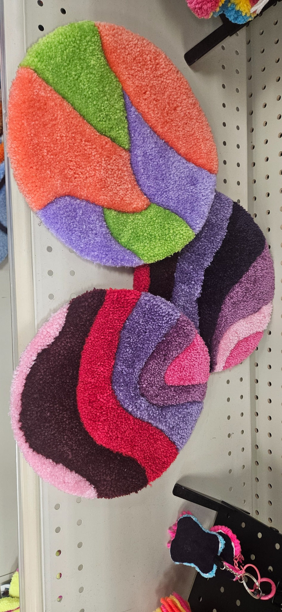 Hand-tufted fiber art pot warmers in three colorful abstract designs