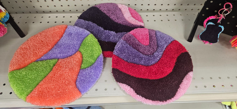 Hand-tufted fiber art pot warmers in three colorful abstract designs
